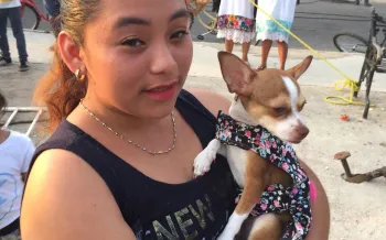 A woman holding a dog.