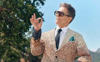 Kevin Bacon (aka Kevin Bean) holding a bean and wearing sunglasses and a suit covered in a variety of beans.