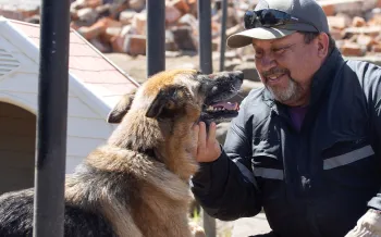 Man and dog outside in the rubble after Child wildfires.