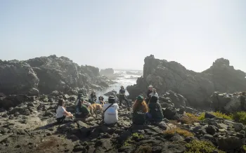A group of people sitting on rocky terrain.