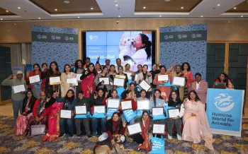 A large group of people posing together at an indoor event.
